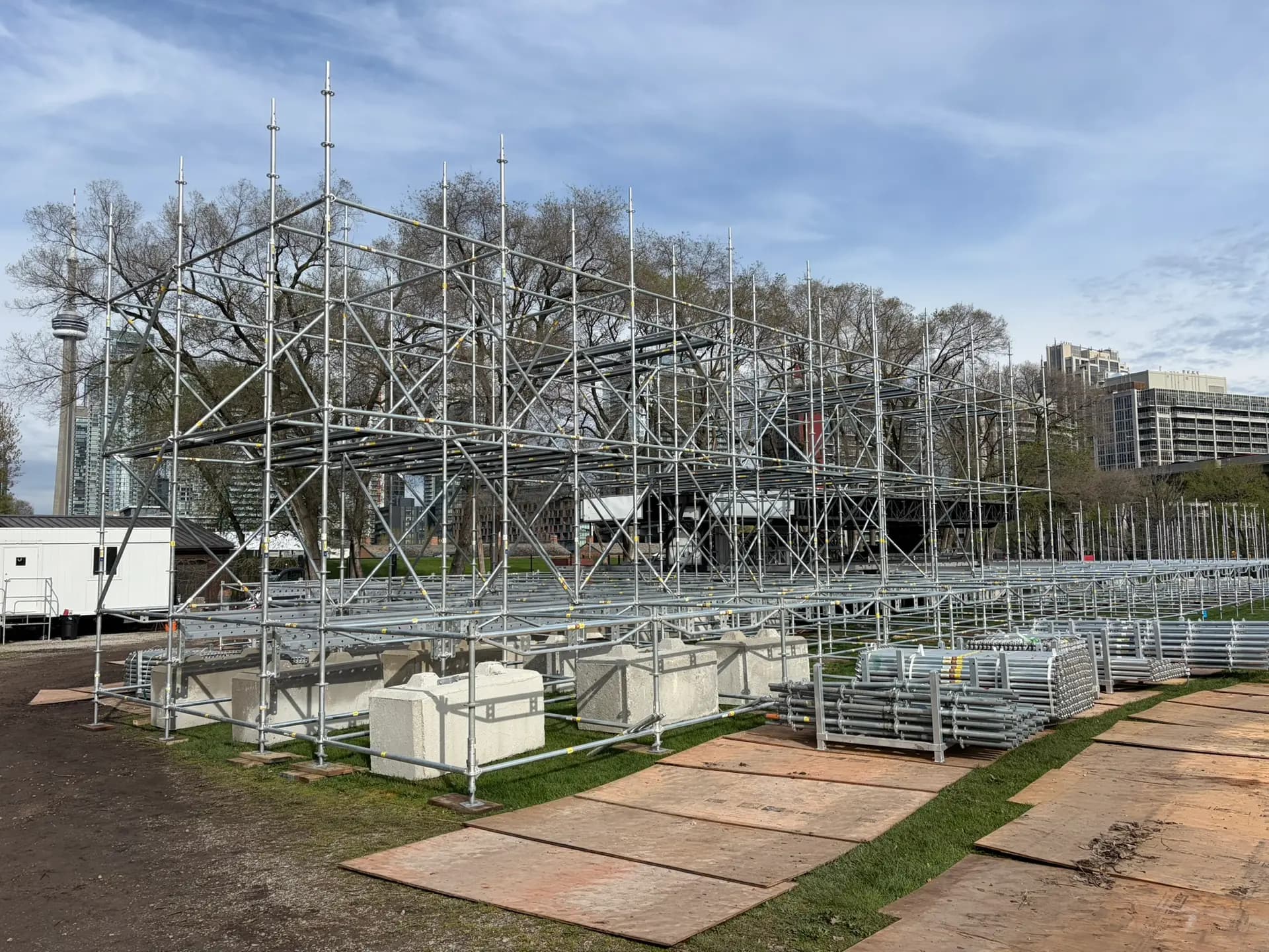 Main stage scaffold structure climbing over the Fort York site with the CN Tower on the Toronto skyline.