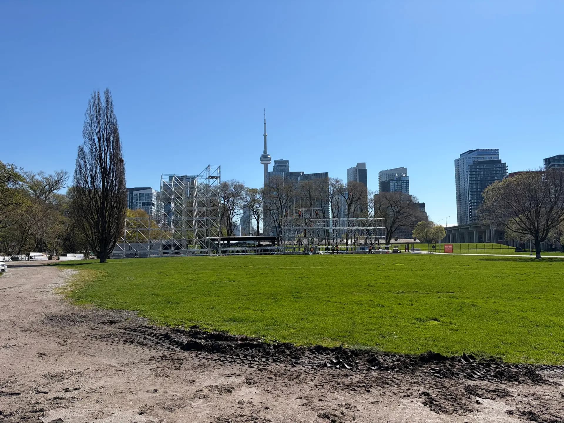 Event scaffold structures at Fort York framed by the CN Tower and downtown Toronto skyline on a clear day