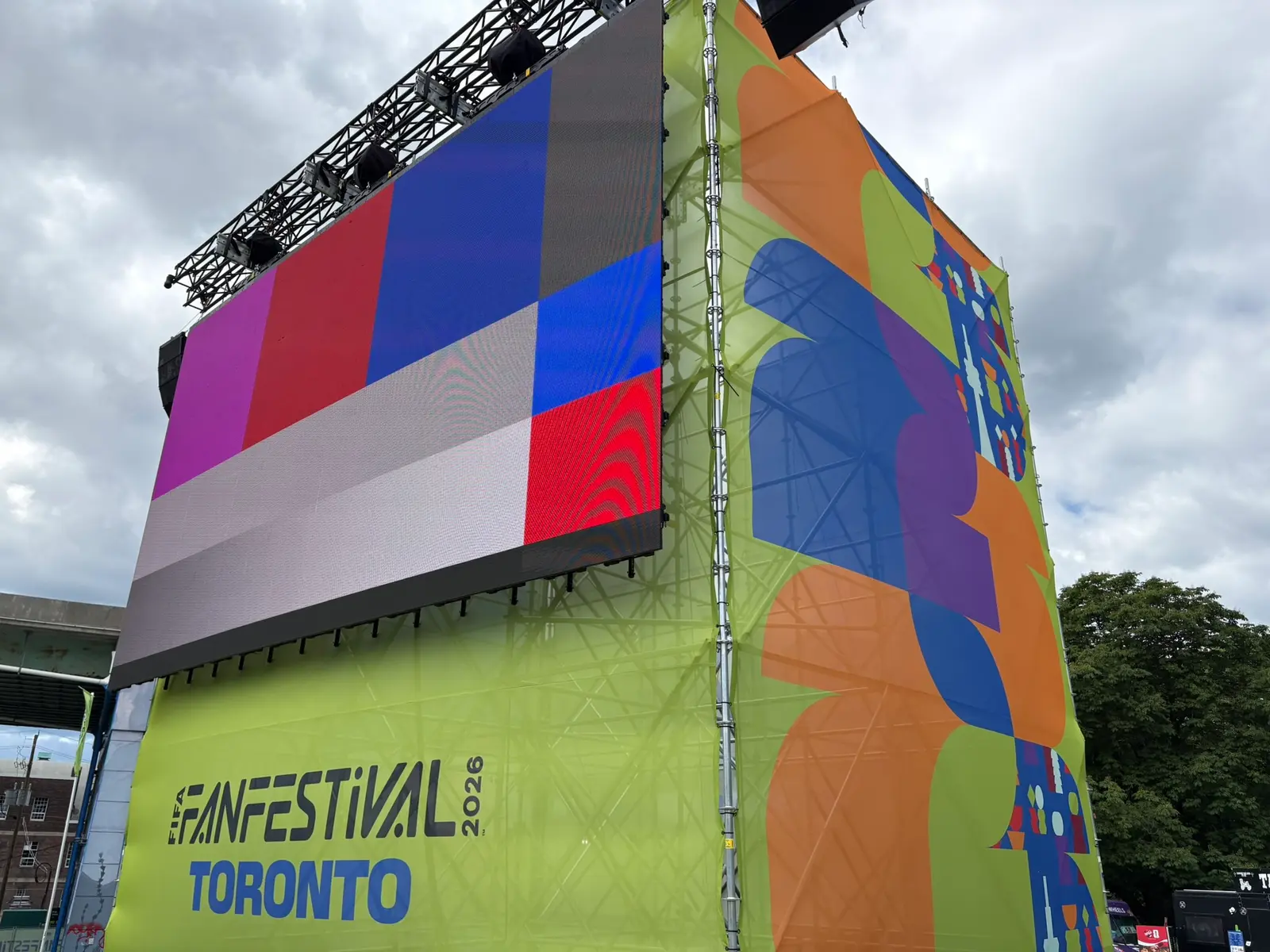 Scaffold-supported LED screen tower wrapped in FIFA Fan Festival branding at a Toronto event site
