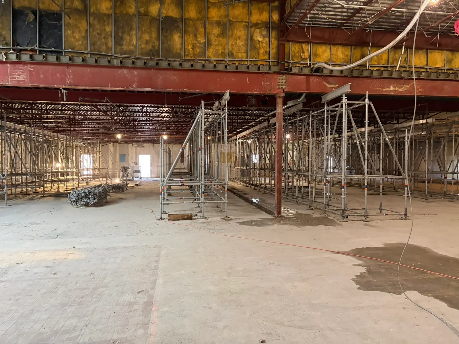 Rows of shoring towers propping structural steel beams during interior demolition and renovation of a commercial building